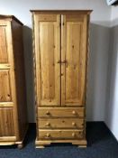 A pine double door wardrobe fitted three drawers