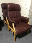 A pair of burgandy leather adjustable armchairs