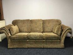 A three piece lounge suite in gold floral print