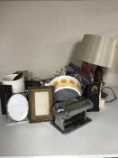 A box of glass ware, pasta maker, oven dishes, table lamp, child's wicker crib of riding hat,