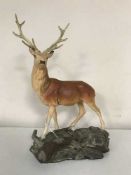 A Beswick figure of a stag standing on a rock,