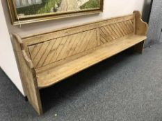 A late Victorian pine pew, 272 cm length.