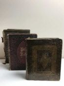 Two antique bibles and a leather bound volume 