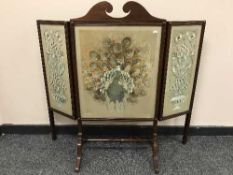 A mahogany three fold embroidered fire screen
