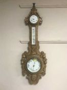 An Edwardian carved oak combination barometer/thermometer/clock