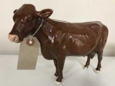 A Beswick figure of a cow in brown gloss finish