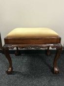 A mahogany claw and ball over sized dressing table stool