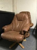 Two brown leather swivel armchairs