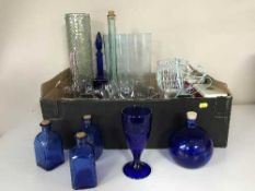 A box of assorted glass ware and two hurricane lamps