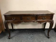 A reproduction mahogany three drawer side table