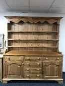 A pine kitchen dresser fitted cupboards and drawer beneath