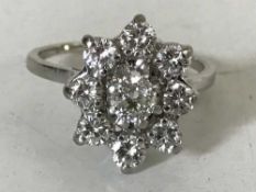 A diamond cluster ring in platinum, central stone approximately 0.