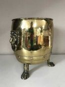 A large brass planter with lion mask handles