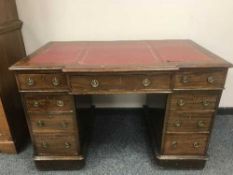 An Edwardian mahogany breakfront pedestal desk with tooled leather top