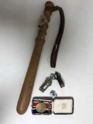 A policeman's truncheon and a bag of cased defence medal and two whistles
