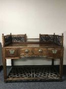An oriental hardwood writing desk with fret work panels