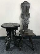 A heavily carved oak spinning chair and an ebonised occasional table