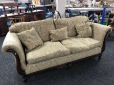 A two seater scroll arm settee in gold fabric