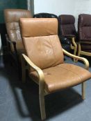 Two brown leather wood framed armchairs