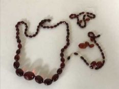 Two straps of faceted cherry amber beads, one in need of restringing, 76.