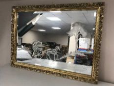 A gilt framed etched mirror depicting horse drawn carriage
