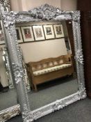 A rectangular silivered ornate framed mirror,