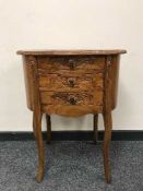 A carved oval mahogany three drawer chest