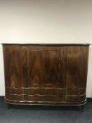 A walnut bow-fronted triple door sideboard