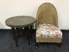 A folding brass topped table and loom basket chair