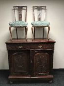 A carved cabinet and two mahogany chairs