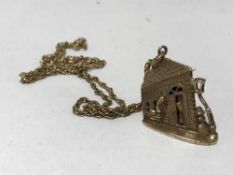 A 9 ct gold necklace with a 9 ct gold pendant of a corner house