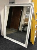 A large decorative white framed mirror