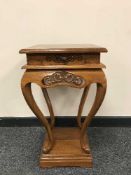 A carved mahogany lamp table fitted a drawer