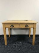 An early 20th century oak writing table fitted two drawers