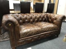 A brown buttoned leather Chesterfield two seater settee