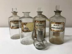 Four antique glass chemist's jars and a small glass paraffin lamp