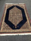 A fringed Persian Tabriz rug with central medallion on blue ground,