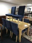 A large beech dining table fitted a drawer and eight upholstered chairs
