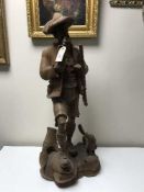 A large carved black forest style figure of a huntsman with dog