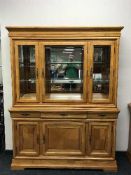 A colonial style triple door display cabinet