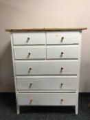 A pine topped seven drawer chest and a pair of white bedside chests