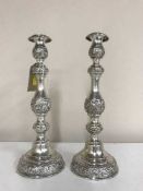 A pair of sterling silver embossed candlesticks, bearing London hallmarks, dated 1921, height 29.