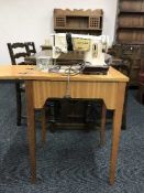 A singer electric sewing machine in teak table