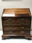 A miniature Victorian style mahogany bureau on bracket feet