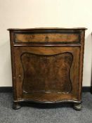 A walnut single door cabinet fitted a drawer