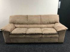 A three piece lounge suite in a light brown fabric and footstool