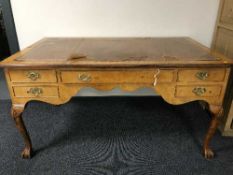 An antique walnut writing desk on claw and ball feet with tooled leather inset top