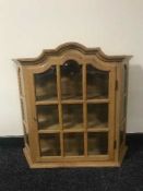 An oak wall mounted curio cabinet