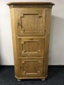 An oak triple door corner cabinet