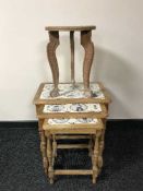 A nest of three tiled topped tables and plant table